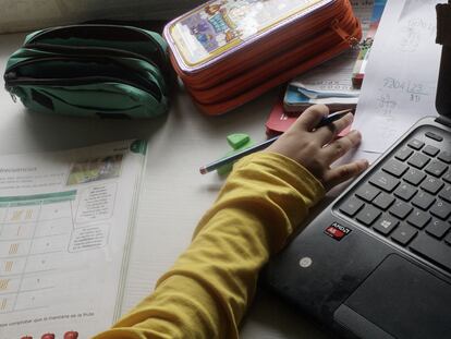 Un niño estudiando en su casa.