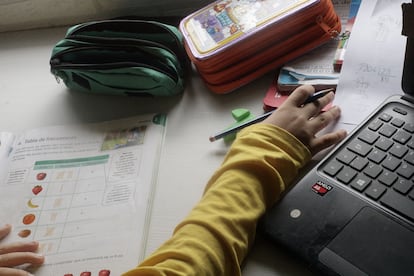 Un niño estudiando en su casa.