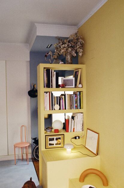 El módulo de pladur amarillo articula gran parte de la vivienda. Las dos lámparas también son obra de Enrich. Al fondo, la silla Patio en su obligatorio color rosa.