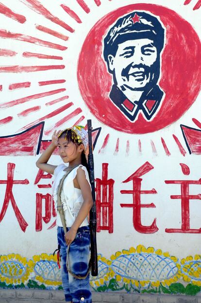 Los valores comunistas todavía se inculcan en clase, aunque de Mao Tsetung sólo se dice que fue un gran hombre y un gran líder. Cada lunes se celebra la ceremonia de izado de bandera, al pasar de ciclo se promete respetar el liderazgo del Partido. En la fotografía, una niña posa con un fusil de juguete frente al retrato del líder político.