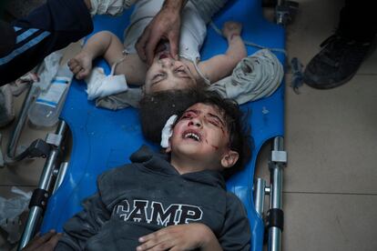 Dos niños palestinos esperan a ser atendidos en el hospital Der Al Balah tras un ataque israelí.