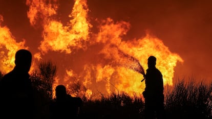 Bomberos intentan apagar el incendio en la localidad de Dionysos, cerca de Atenas, este lunes.