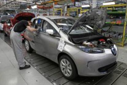 An employee works on a Renault Zoe electric car on the production line at the Renault automobile factory in Flins, west of Paris, May 28, 2013.   REUTERS/Benoit Tessier   (FRANCE - Tags: TRANSPORT BUSINESS INDUSTRIAL)