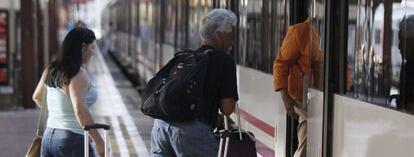 Varias personas montan a un tren en la estaci&oacute;n de Chamart&iacute;n, en Madrid. 