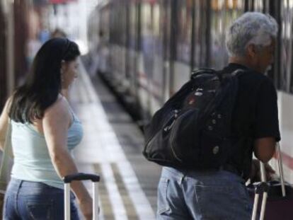Varias personas montan a un tren en la estaci&oacute;n de Chamart&iacute;n, en Madrid. 