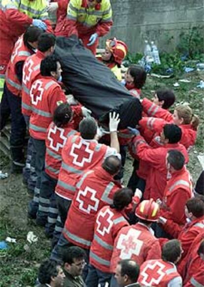 Los equipos de rescate trasladan el cadáver de una víctima.