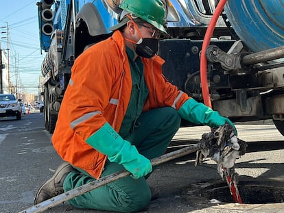 Un trabajador de Acueducto de Bogotá realiza la limpieza de una alcantarilla.