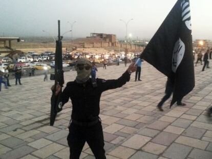 Un miliciano levanta una bandera del Estado Islámico, tras la toma de Mosul en junio de 2014.