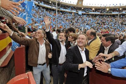 Esteban González Pons, Mariano Rajoy y Alberto Fabra responden a los saludos en la plaza de toros de Valencia, con unos 15.000 asistentes al mitin.