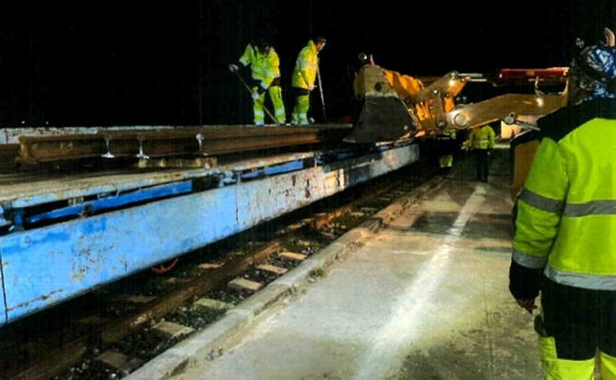 Varios operarios trabajan en el traslado a la base de Adif en Hornachuelos (Córdoba) de los carriles retirados de la línea de alta velocidad Madrid-Sevilla en la zona de Adamuz (Córdoba), en imagen recogida por agentes de la Guardia Civil.