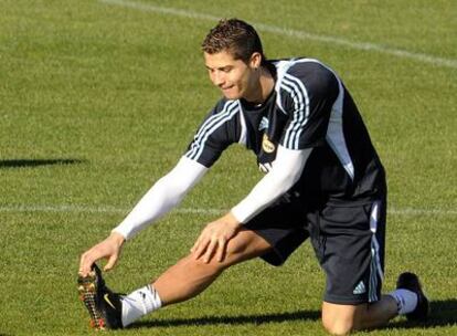 Cristiano Ronaldo realiza estiramientos durante el entrenamiento de ayer del Madrid.