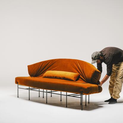 El diseñador Lucas Muñoz Muñoz con el sofá que ha creado para el Ateneo de Madrid.