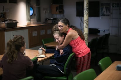 Marina, activista y Pino, ayudante de cocina, se abrazan, durante el desayuno.