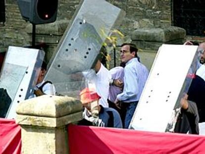 La policía protege con escudos al alcalde de Vitoria, Alfonso Alonso, del lanzamiento de huevos.