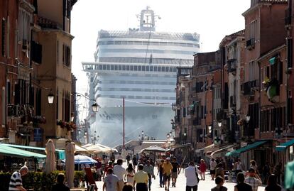 El crucero MSC Divina visto entre edificios de Venecia mientras surca la laguna de Venecia. La sobreexplotación turística de Venecia, la ciudad del mundo más afectada por esta industria (55.000 habitantes frente a 24 millones de visitantes al año), ha tocado fondo con la llegada de cruceros. Este año han desembarcado 2,5 millones de pasajeros y el encanto de su laguna ha vuelto a convertirse en una grotesca postal con barcos gigantes a pocos metros del Palacio Ducal