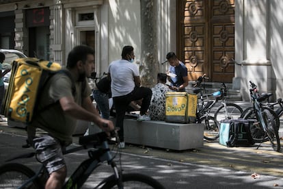 En la imagen repartidores de Glovo frente a un restaurante del Eixample izquierdo de Barcelona.