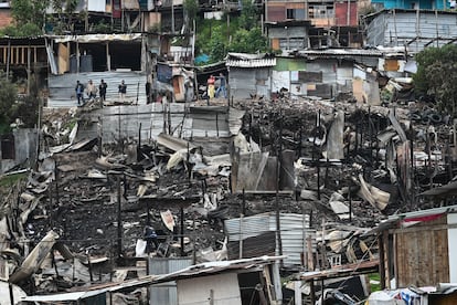 Vecinos del barrio observan la destrucción traída por el incendio.