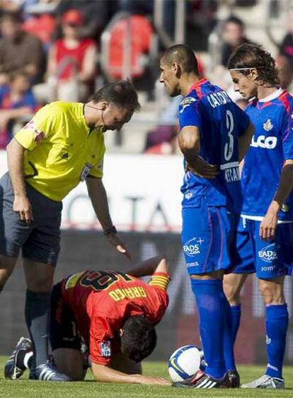 El colegiado Medina Cantalejo y los jugadores del Getafe Cortés (derecha) y 'Cata' Díaz esperan mientras Arango se duele sobre el césped.