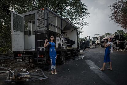 Dos mujeres toman fotos delante de camiones abandonados de la policía fuera de la Casa de Gobierno en Bangkok. El primer ministro tailandés Yingluck Shinawatra el 10 de diciembre rechazó las demandas de los manifestantes contra el gobierno que renuncie antes de las próximas elecciones, instándolos a abandonar "revolución popular" su autoproclamado.