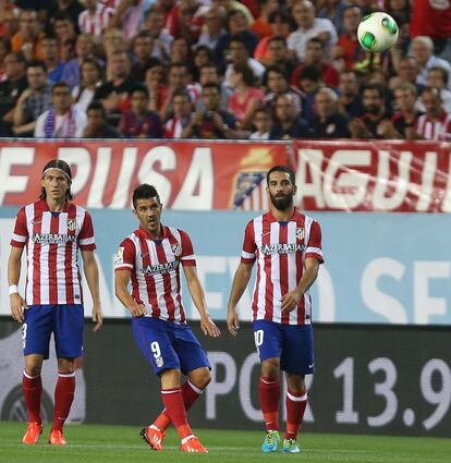 Filipe Luis, Villa y Turan observan como el balon se dirige hacia la porteria lanzado por el asturiano intentando sorprender desde el centro del campo.