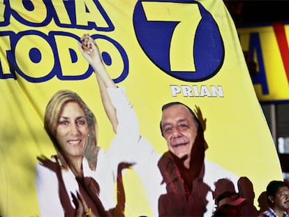 Un cartel del candidato presidencial de Ecuador Alvaro Noboa junto a su esposa y candidata a diputada Anabella Azin, durante un acto político realizado la noche de ayer, jueves 19 de octubre, en un populoso sector de la ciudad de Guayaquil, Ecuador