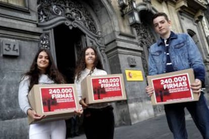 De izquierda a derecha, P. Santiago, A. P. García e I. Martínez, sosteniendo las cajas que simbolizan las 240.000 firmas contra las reválidas.