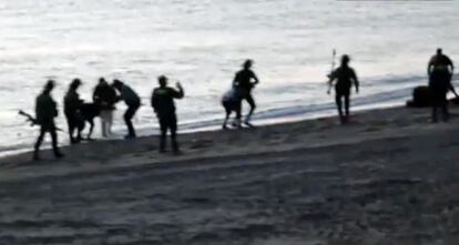 Los guardias civiles devuelven a inmigrantes a Marruecos en la playa deTarajal.