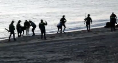 Civil Guard officers return undocumented migrants to Morocco at Tarajal beach.