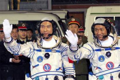 Los astronautas chinos Fei Junlong (izquierda) y Nie Haisheng saludan antes del lanzamiento.