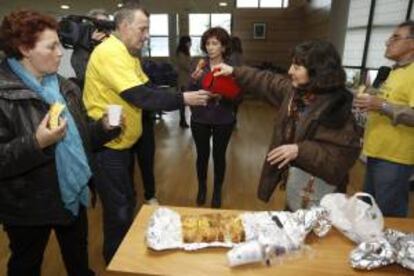 Vecinos afectados por las participaciones preferentes y subordinadas desayunan durante el encierro que comenzó ayer por la tarde en el ayuntamiento de Moaña tras la suspensión del pleno municipal.