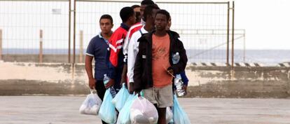 Un grupo de inmigrantes camina por el puerto de Lampedusa (Italia). 