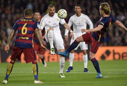 Karim Benzema rivaliza con el mediocampista croata de Barcelona Ivan Rakitic, durante el partido entre el FC Barcelona y el Real Madrid CF.