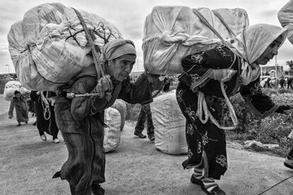 En el paso fronterizo del barrio chino, cerca de Beni-Enzar, para entrar a Melilla, dos mujeres ancianas cargan pesados fardos de mercancía sobre sus espaldas.