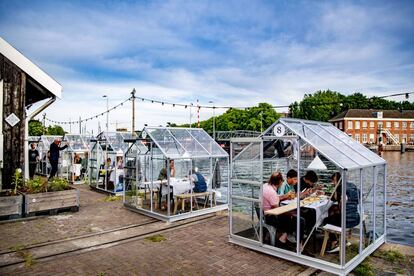 Los clientes de un restaurante de Ámsterdam ocupan pequeños invernaderos para mantener la distancia de seguridad.