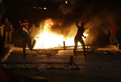 Partidarios del derrocado Morsi lanzan piedras a sus opositores durante los enfrentamientos de anoche en El Cairo. 