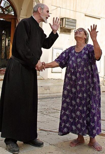 Un sacerdote y una mujer, ayer frente a una iglesia de Bagdad.