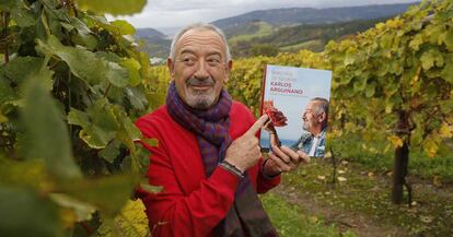 Karlos Arguiñano posa con su último libro en el viñedo de su bodega de chacolí.