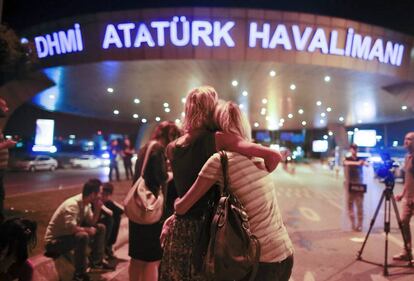 Unos pasajeros se abrazan en el exterior del principal aeropuerto de Estambul.