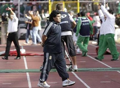 Diego Armando Maradona vuelve a su banquillo mientras los bolivianos celebran uno de sus goles.