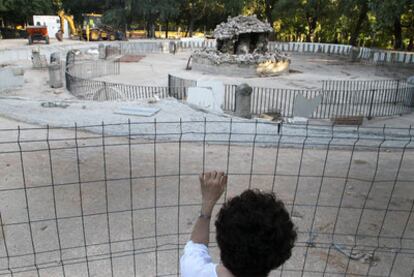 Una persona mira las obras en la fuente Campanillas, en el parque del Retiro.