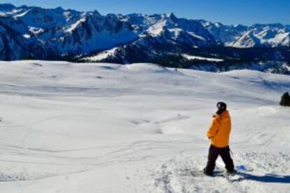 Un hombre hace snowboard en la primera nieve de la temporada en Baqueira.