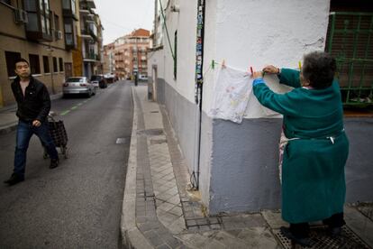 Una mujer tiende fuera de su casa, en Tetuán. El distrito, al noroeste de Madrid, cuenta con 150.000 habitantes y sus 540 hectáreas están divididas en seis barrios: Bellas Vistas, Berruguete, Valdeacederas, Almenara, Castillejos y Cuatro Caminos. Surgido a finales del siglo XIX, la parte oeste, con una trazado irregular y en algunos puntos abandonada, contrasta con el margen derecho, más rico y desarrollado.