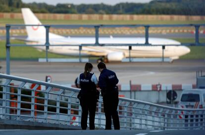 Agentes de la policía belga patrullan mientras que un avión aterriza en el aeropuerto de Zaventem (Bélgica).