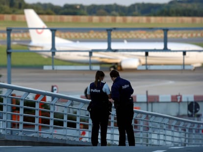Agentes de la policía belga patrullan mientras que un avión aterriza en el aeropuerto de Zaventem (Bélgica).
 