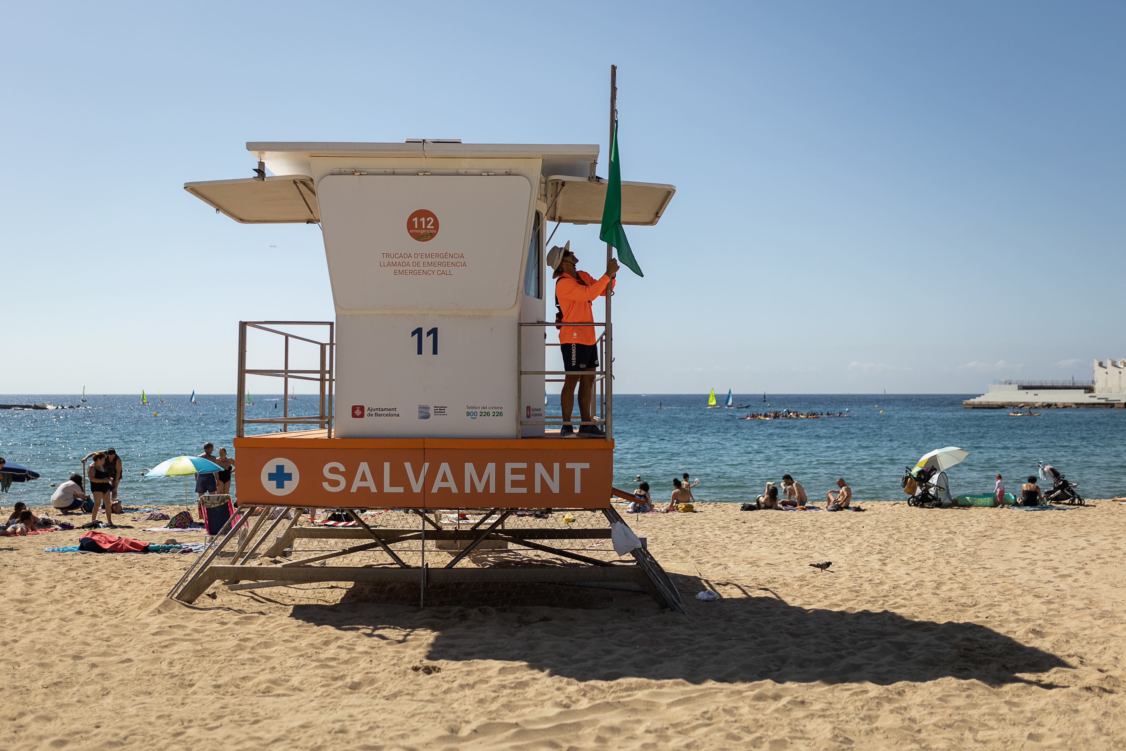 Una socorrista pone la bandera verde en una playa de Barcelona, en una fotografía de 2022.