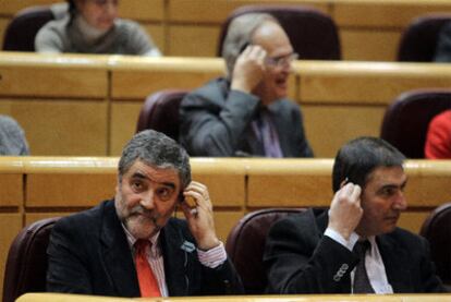 Un grupo de senadores del PSC utilizando ayer el <i>pinganillo.</i> A la izquierda, Ramón Aleu.