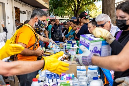 Voluntarios reparten comida en Benetússer (Valencia), este sábado. 