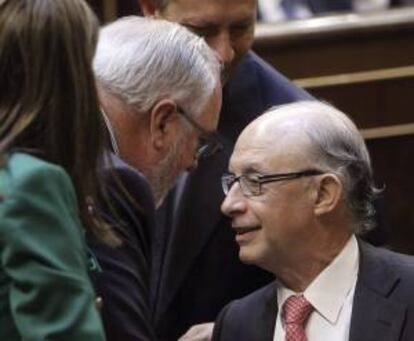 El ministro de Hacienda, Cristóbal Montoro (d), conversa con el ministro de Agricultura, Miguel Arias Cañete, durante el pleno celebrado hoy en el Congreso.