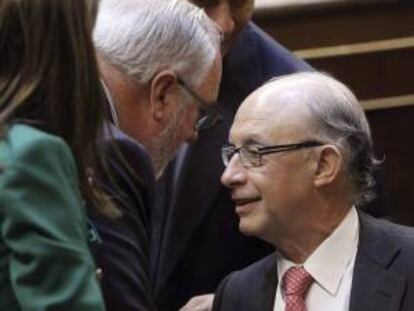 El ministro de Hacienda, Cristóbal Montoro (d), conversa con el ministro de Agricultura, Miguel Arias Cañete, durante el pleno celebrado hoy en el Congreso.
