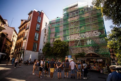 Unos turistas escuchan a un guía ante los murales de Puerta Cerrada en La Latina, llenos de grafitis este viernes.